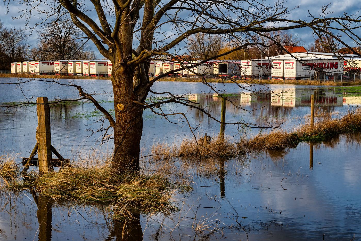 Blick über die vom Hochwasser überschwemmte Wiese auf den Betriebshof